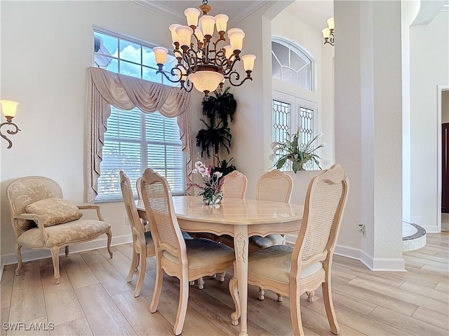 dining room with a chandelier, a high ceiling, baseboards, and light wood-style floors