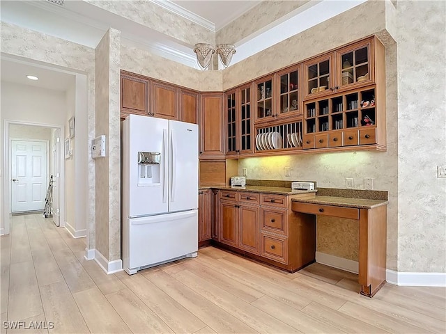 kitchen with white fridge with ice dispenser, brown cabinets, light wood-style floors, and glass insert cabinets