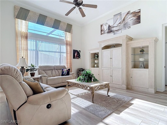 living room with ceiling fan, built in shelves, light wood-style flooring, and crown molding