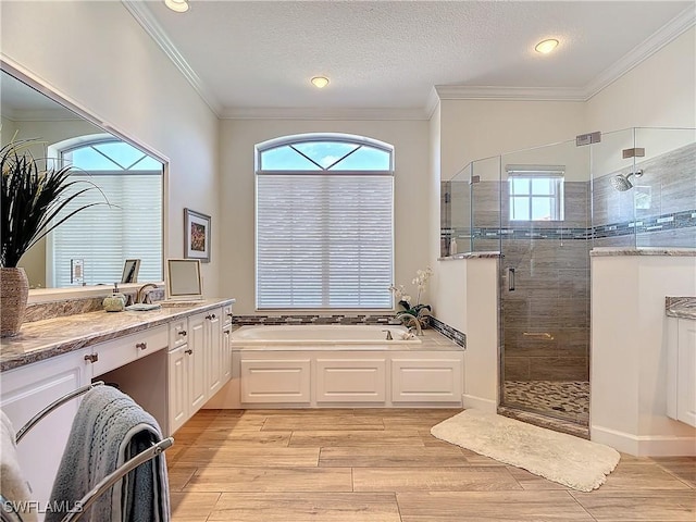 full bathroom featuring a stall shower, a garden tub, crown molding, and wood finished floors