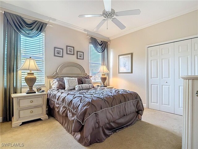 bedroom with a closet, ornamental molding, light carpet, ceiling fan, and baseboards