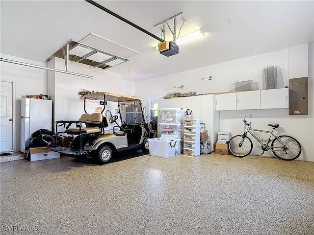 garage with freestanding refrigerator, electric panel, and a garage door opener