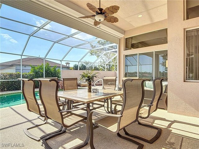 view of patio featuring outdoor dining space, a lanai, a fenced in pool, and a ceiling fan