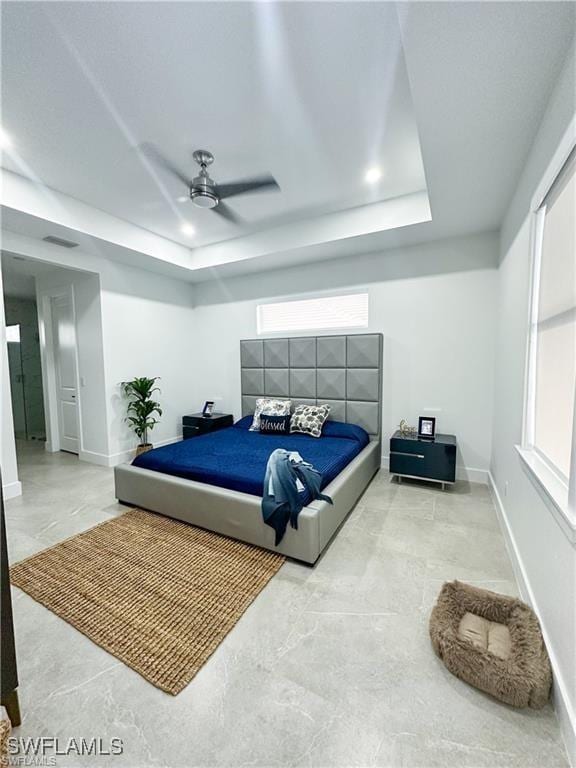 bedroom featuring ceiling fan and a tray ceiling