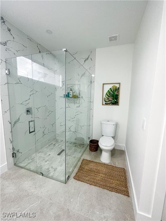 bathroom with a shower with shower door and toilet