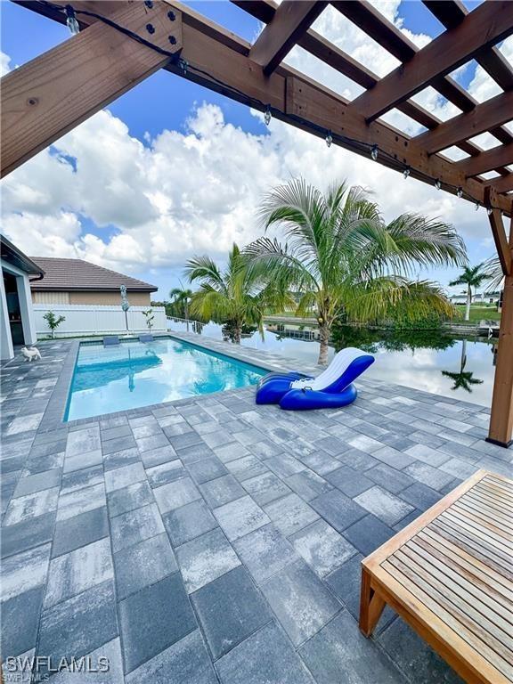 view of pool with a pergola, a patio area, and a water view