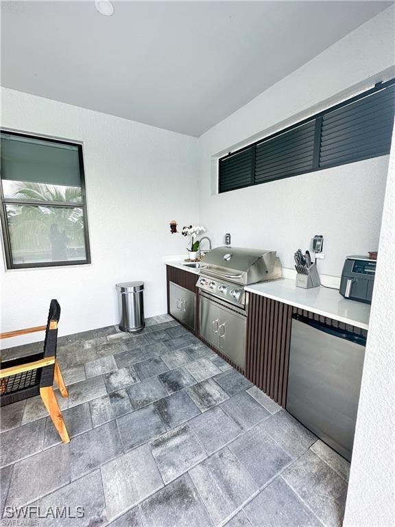 kitchen featuring stainless steel fridge and dark brown cabinets