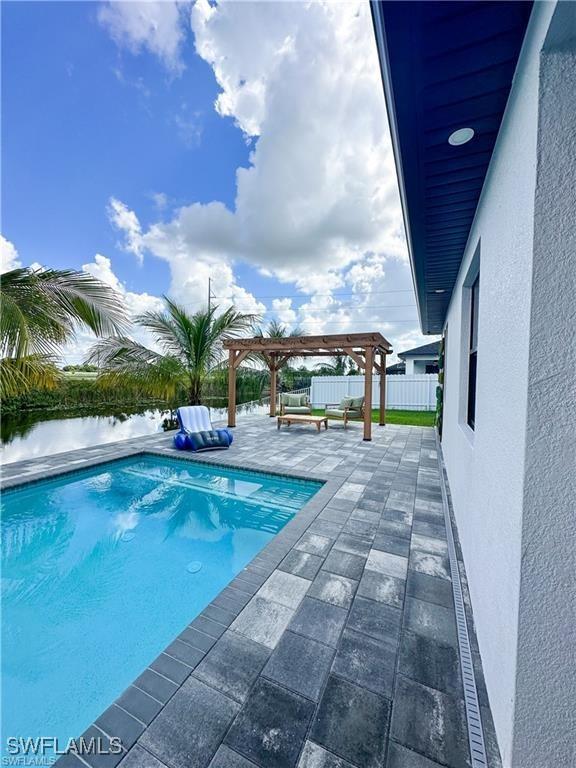 view of pool featuring a patio, a water view, and a pergola