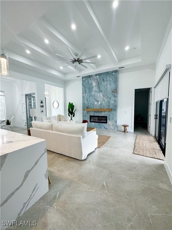 living room featuring a tile fireplace and ceiling fan