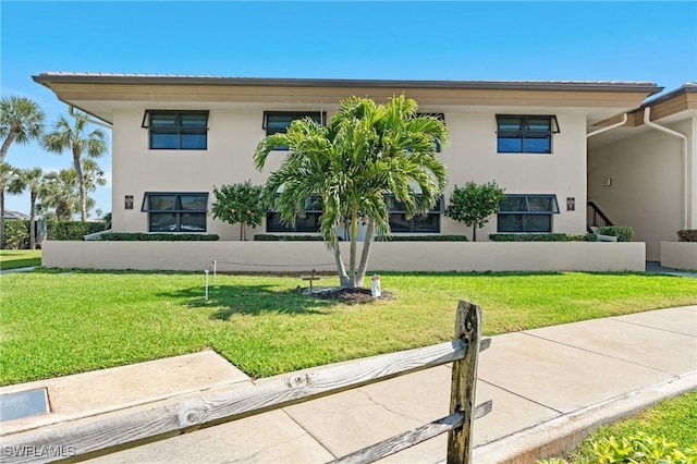 view of front facade featuring a front lawn and stucco siding