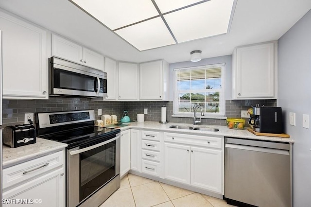 2228 Poinciana Dr, Naples, FL 34105 - kitchen featuring decorative backsplash, white cabinetry, a sink, and stainless steel appliances