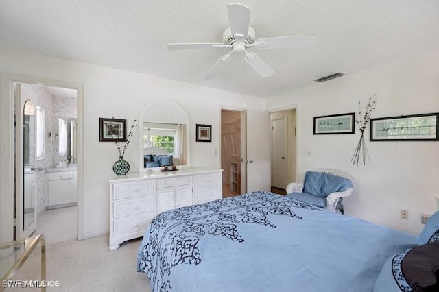 2228 Poinciana Dr, Naples, FL 34105 - bedroom featuring ensuite bathroom, a textured ceiling, visible vents, ceiling fan, and light colored carpet