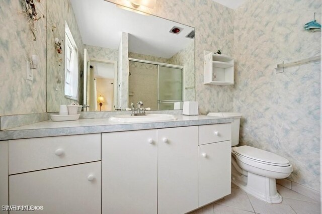 2228 Poinciana Dr, Naples, FL 34105 - full bathroom with vanity, toilet, wallpapered walls, tile patterned floors, and a stall shower