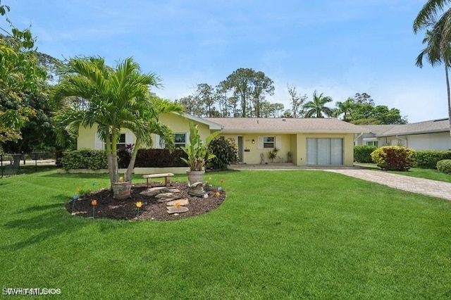 2228 Poinciana Dr, Naples, FL 34105 - rear view of property with decorative driveway, stucco siding, a garage, and a yard