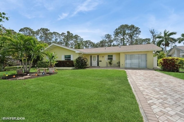 2228 Poinciana Dr, Naples, FL 34105 - ranch-style house with a garage, decorative driveway, stucco siding, and a front lawn