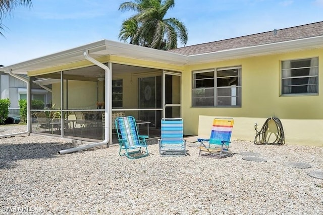 2228 Poinciana Dr, Naples, FL 34105 - back of property with stucco siding, a sunroom, and a shingled roof