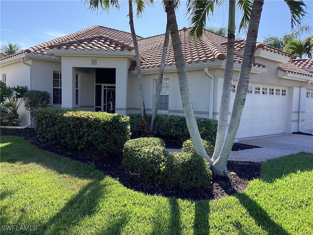 mediterranean / spanish-style home featuring a garage and a front yard