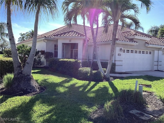 mediterranean / spanish home with a garage and a front yard