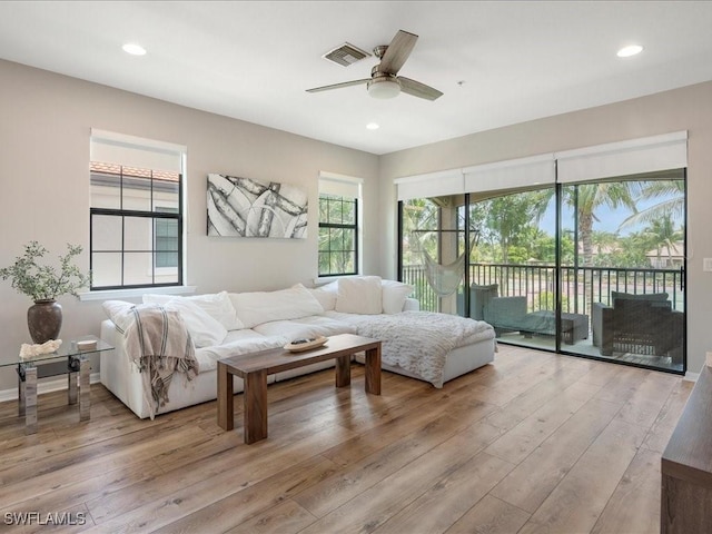 living area featuring visible vents, hardwood / wood-style floors, and recessed lighting