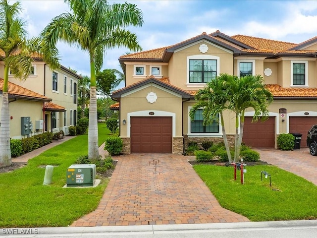 mediterranean / spanish home with stone siding, decorative driveway, and stucco siding