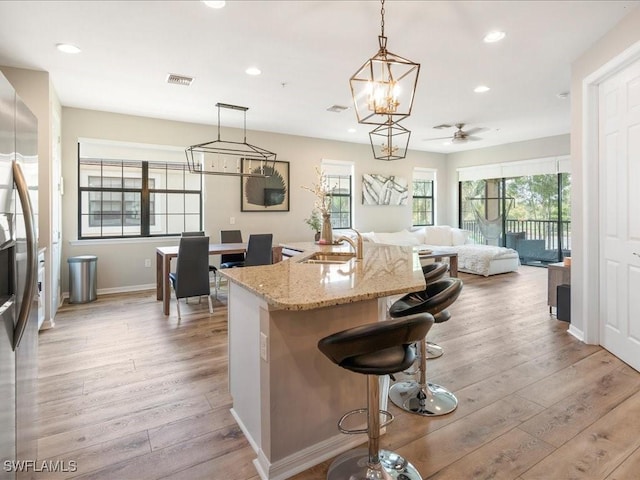 kitchen with visible vents, stainless steel fridge with ice dispenser, light wood-style flooring, a sink, and recessed lighting