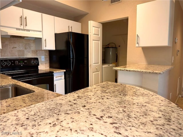 kitchen with water heater, white cabinetry, light stone counters, black appliances, and decorative backsplash