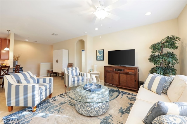 living area featuring a ceiling fan, arched walkways, and recessed lighting