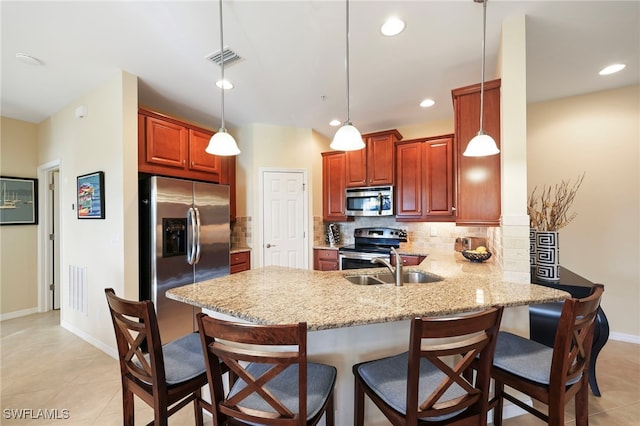 kitchen featuring a peninsula, stainless steel appliances, visible vents, tasteful backsplash, and decorative light fixtures