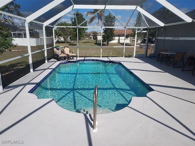 view of pool featuring glass enclosure and a patio