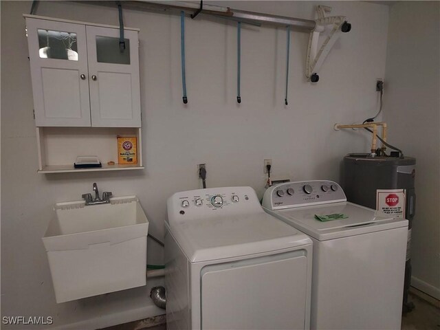 clothes washing area featuring electric water heater, sink, and washer and clothes dryer