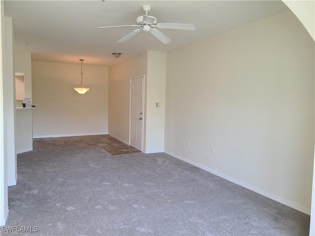 carpeted spare room with ceiling fan