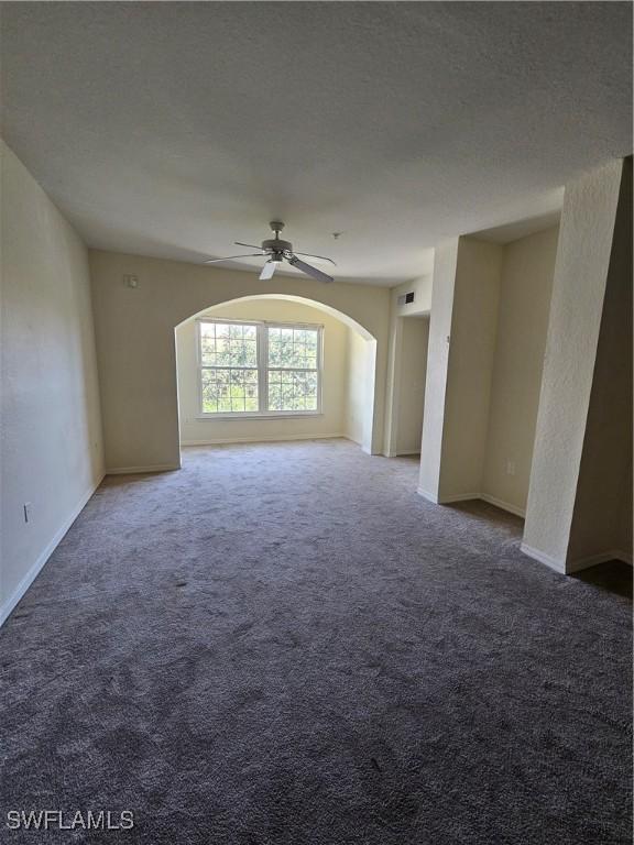 unfurnished room featuring ceiling fan, carpet floors, and a textured ceiling