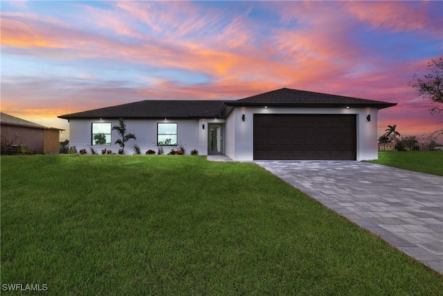 view of front of property featuring a garage and a lawn