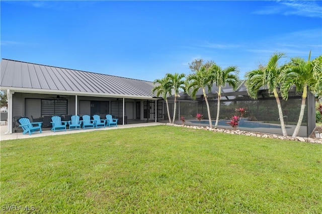 view of yard with glass enclosure and a patio area