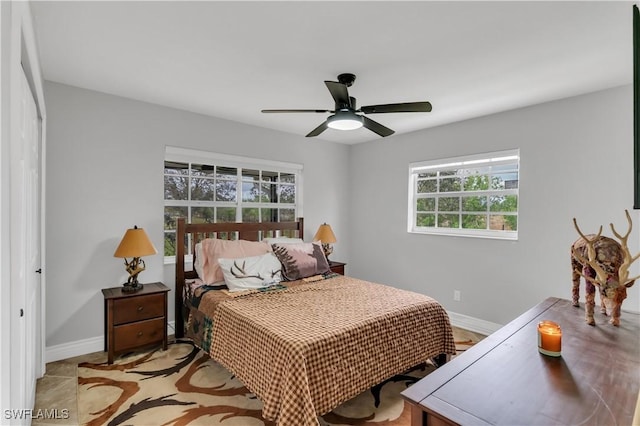 bedroom with a ceiling fan and baseboards