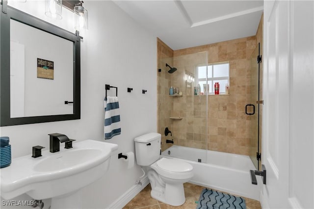 full bath featuring toilet, combined bath / shower with glass door, a sink, tile patterned flooring, and baseboards