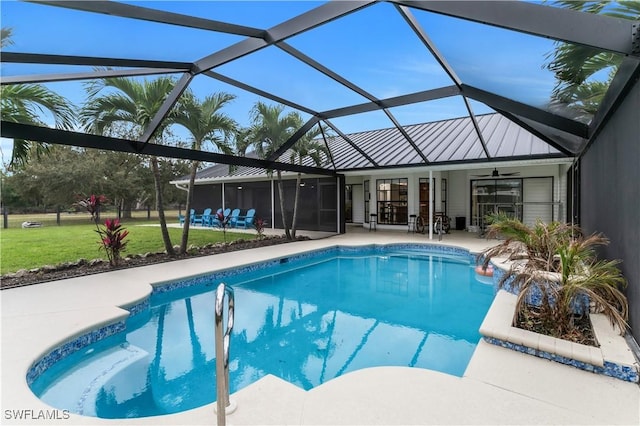 pool featuring glass enclosure, a ceiling fan, and a patio