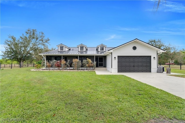 view of front facade featuring a garage, driveway, a front lawn, and a standing seam roof