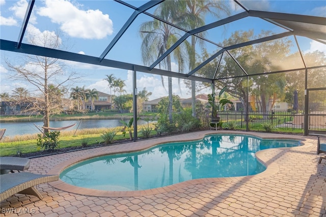 pool featuring a lanai, a water view, a patio, and fence