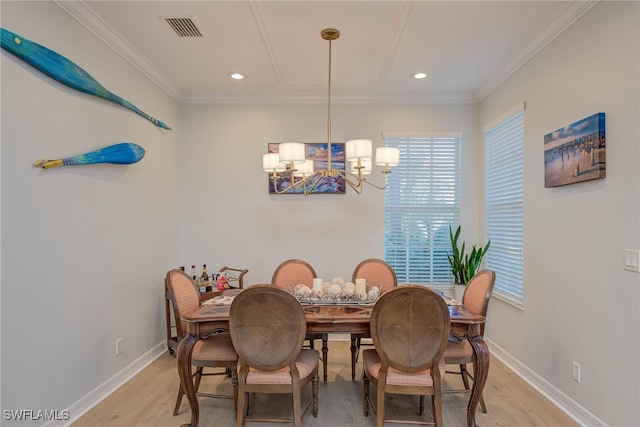 dining space with baseboards, light wood-type flooring, visible vents, and crown molding