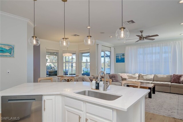 kitchen featuring dishwasher, open floor plan, a sink, and white cabinetry