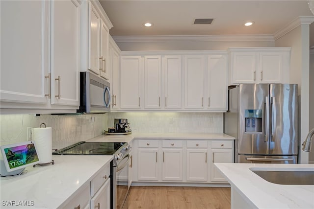 kitchen featuring visible vents, light stone counters, appliances with stainless steel finishes, and white cabinetry