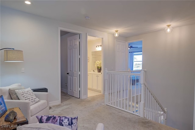 living area featuring recessed lighting, baseboards, and light colored carpet