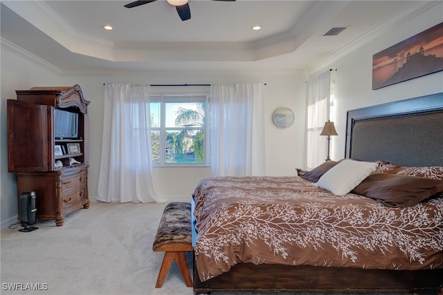 bedroom featuring a tray ceiling, light colored carpet, and crown molding