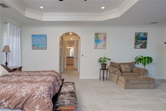 bedroom with light colored carpet, a tray ceiling, arched walkways, and ornamental molding