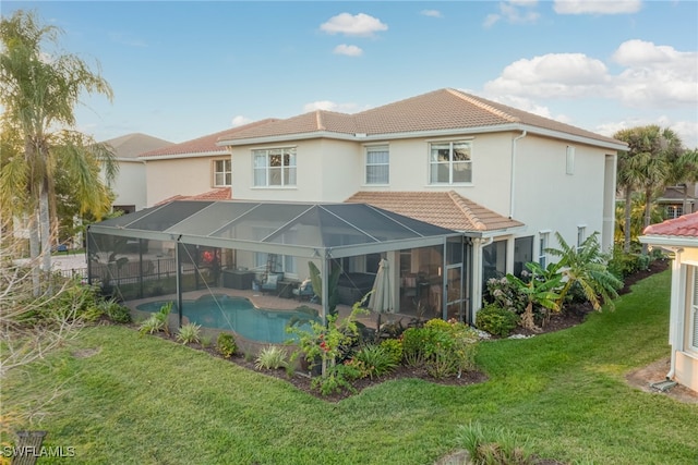 rear view of house featuring a lanai, a yard, an outdoor pool, and a tiled roof