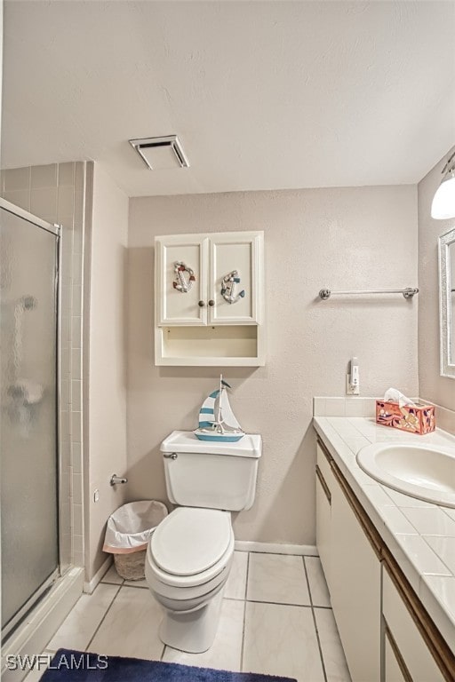 bathroom with tile patterned flooring, vanity, an enclosed shower, and toilet