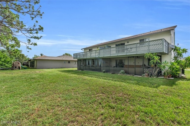 rear view of house with a yard and a playground