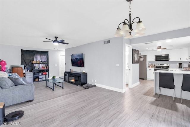 living room featuring ceiling fan and light hardwood / wood-style flooring