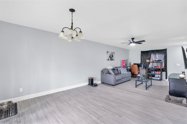 unfurnished living room with ceiling fan with notable chandelier and light hardwood / wood-style floors